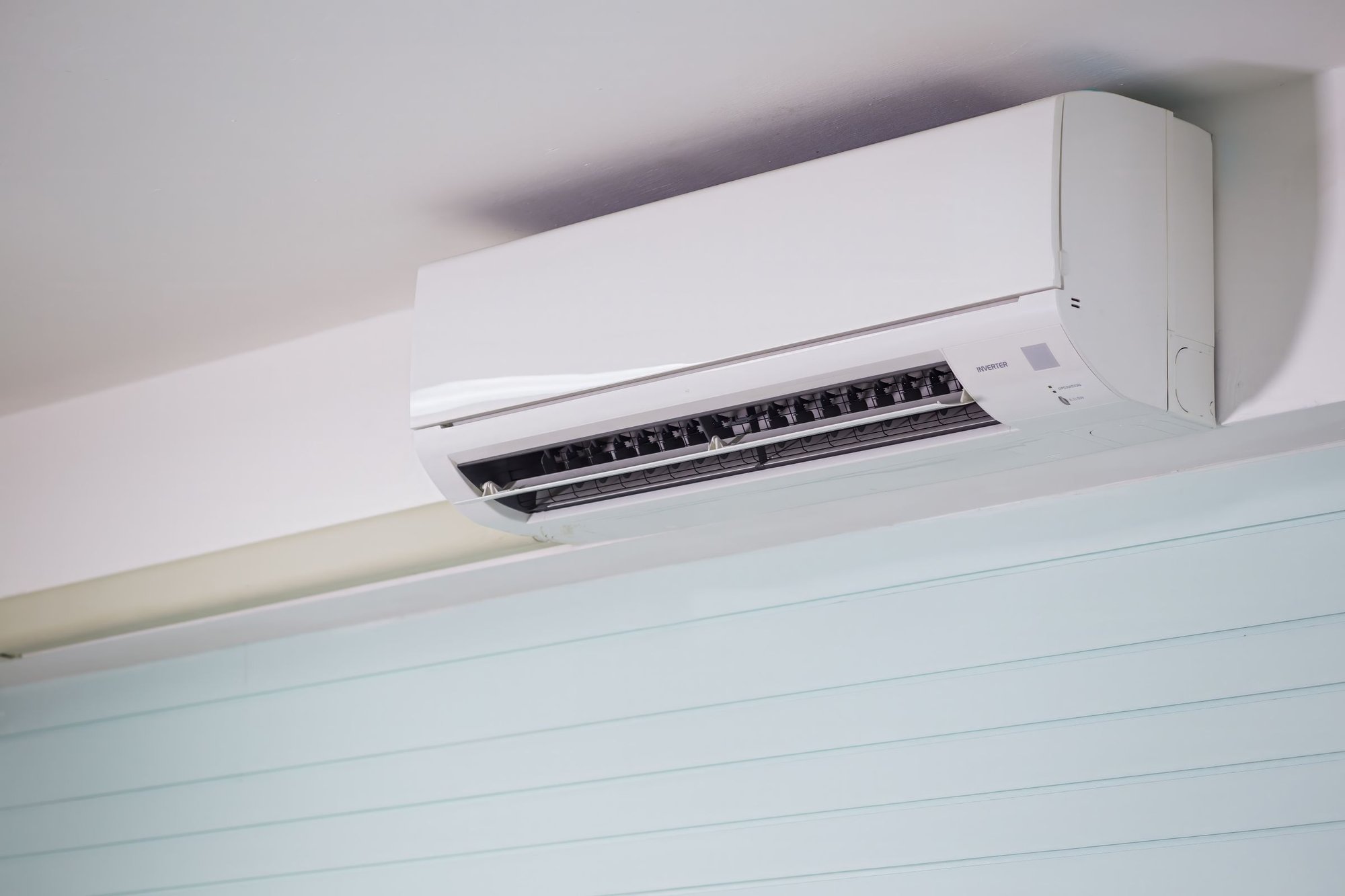 Ductless mini-split air conditioner mounted high on an interior wall